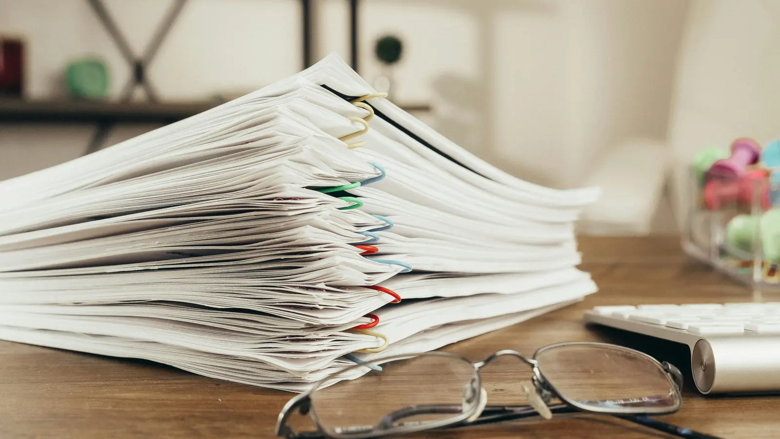 Stack of documents with colorful paperclips representing copyright registration filing