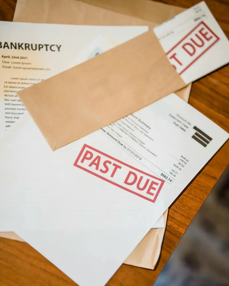 Past due bills and debt notices on a table