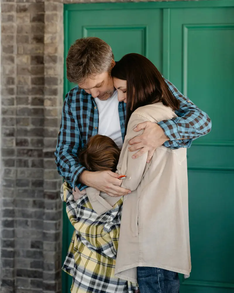Adoptive parent hugging their new family at home in England
