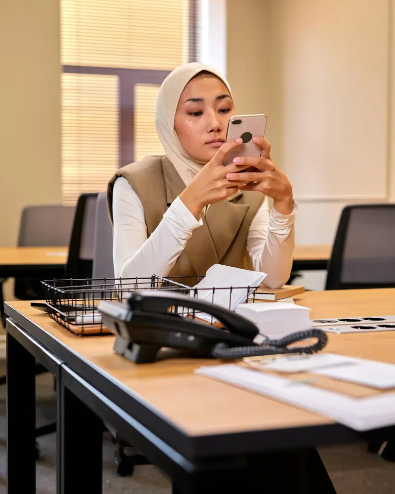 Person mit Aufenthaltsunterlagen am Telefon im Buero
